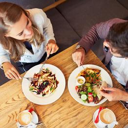 zwei junge Menschen essen zu Mittag an einem Tisch